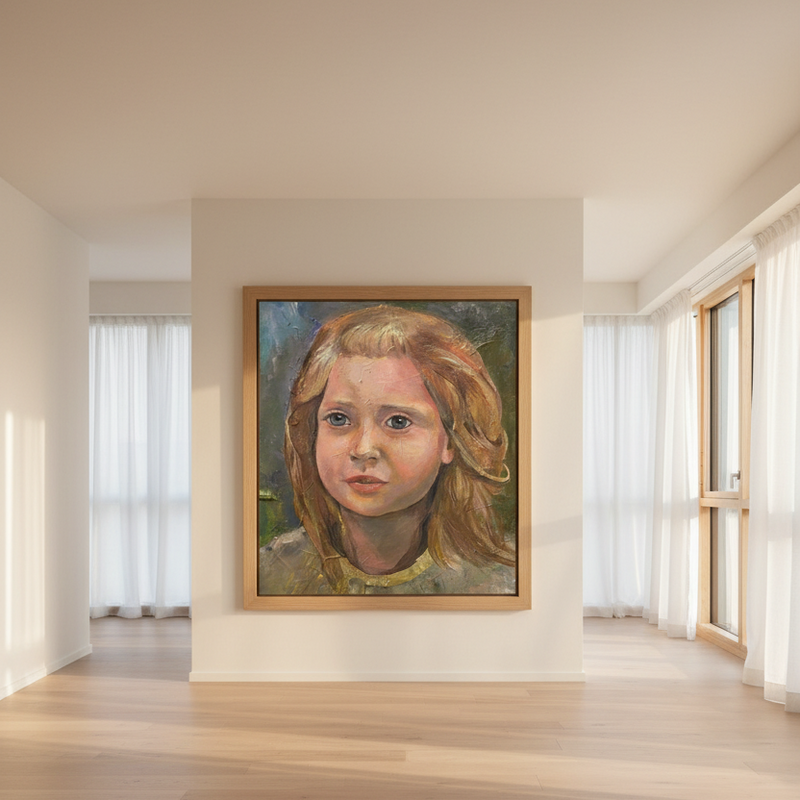 A framed portrait painting of a young girl with light brown hair hangs on a white wall in a bright, modern room with light wood floors and large windows.