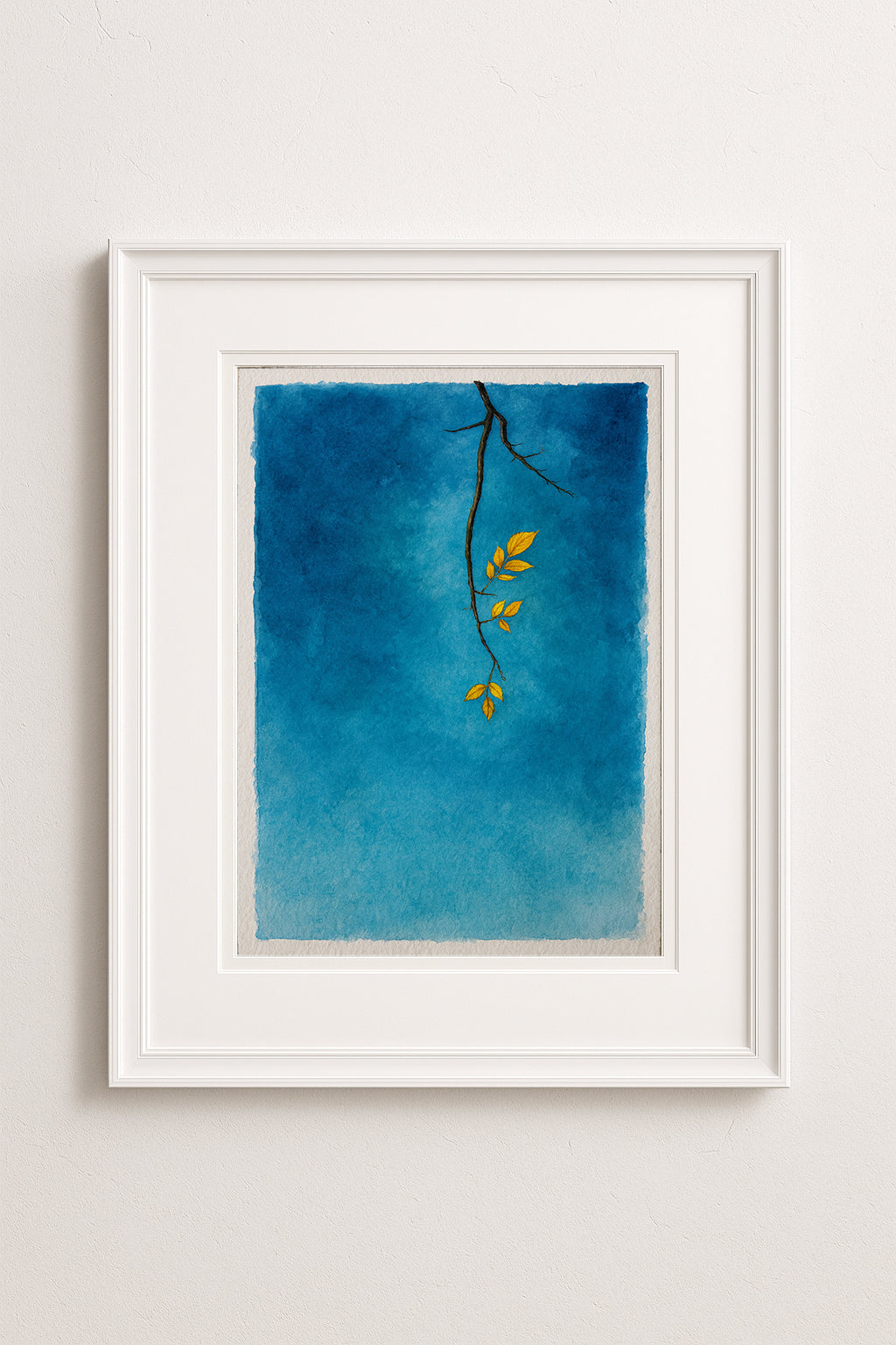 Framed artwork with a blue background and yellow autumn leaves 